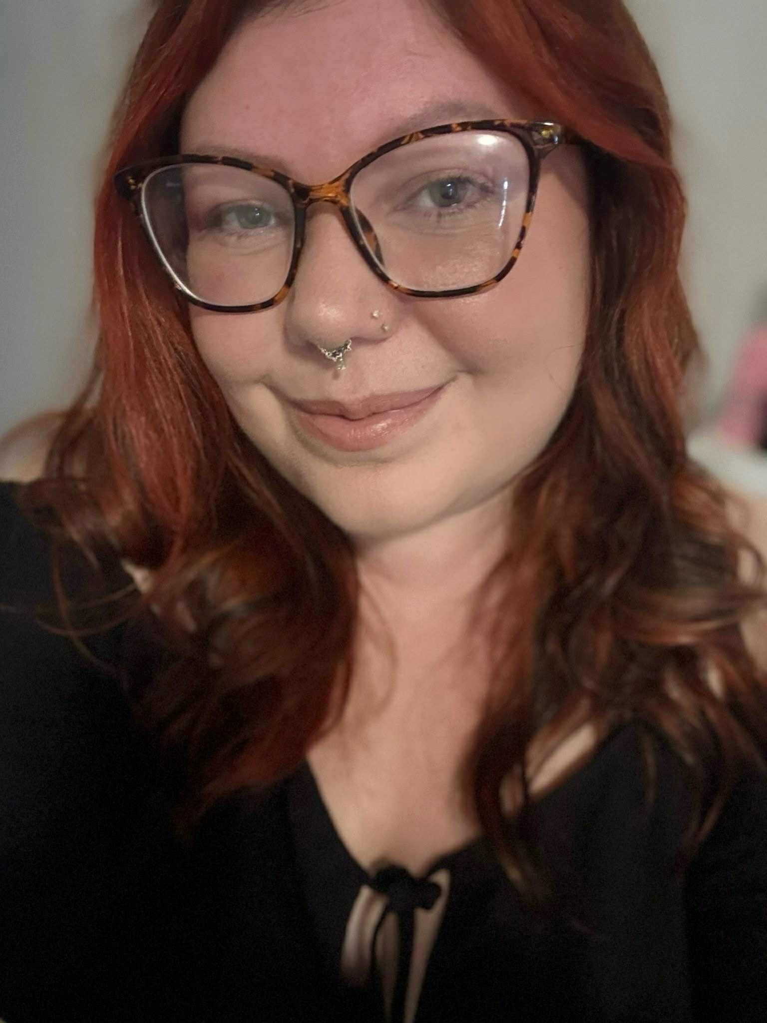 Author Hannah Wilson with long dark reddish hair, glasses, and a black shirt 