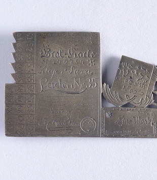 Brooch in the form of a bread ration card made by Chaim Klieger for his sister, Sara in the Łódź Ghetto