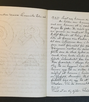 An open journal with white lined pages. On the left page, there are a few lines of text and a few geometric sketches. The right page is filled with handwritten text.