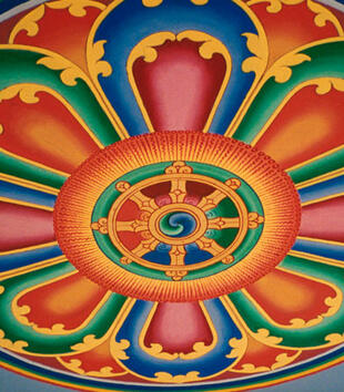 A colorful ceiling mandorla depicts a geometric shape with eight petals surrounding a circular axis mundi. The pattern is painted with vibrant red, green, and blue with yellow outlines.