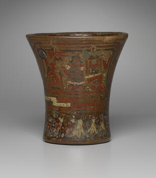 A tumblr-shaped wooden vessel is painted with narrative scenes framed by red and gold lines running across the cup. One depicts a male ruler framed by geometric and animalistic motifs.
