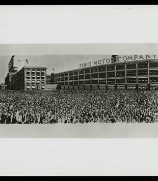 Scan of a panoramic black and white photograph of a crowd assembled outside the Ford Motor Company