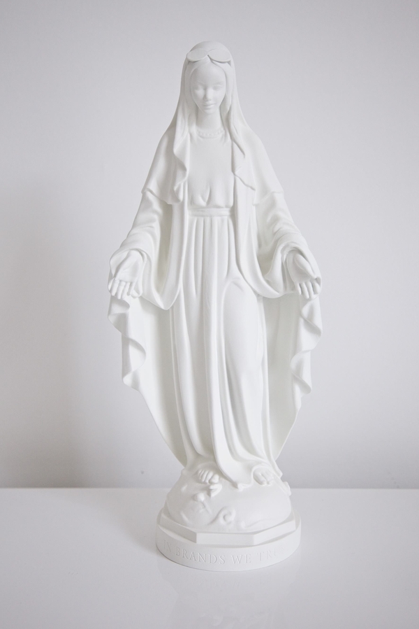A statue of Mary, in matte white finish, in front of a white background.
