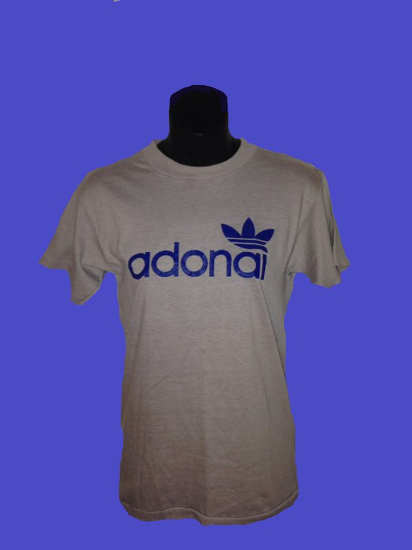 A white t-shirt with blue lettering that reads "Adonai" is displayed on a black clothing form. The text uses the same geometric sans font used by Adidas, and the trefoil corporate logo is included in blue above the "ai."   