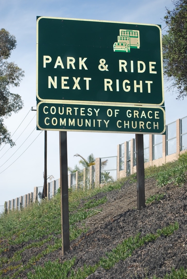 A smaller sign is affixed below a large sign for a "Park and Ride." It reads, "Courtesy of Grace Community Church."