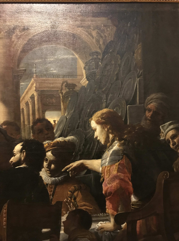 A detail of an oil painting of the Feast of Absalom focuses on Absalom standing at the head of a banquet table. His hand is raised to order the murder of his brother Amnon. In the background, there is an array of gleaming silver plates.