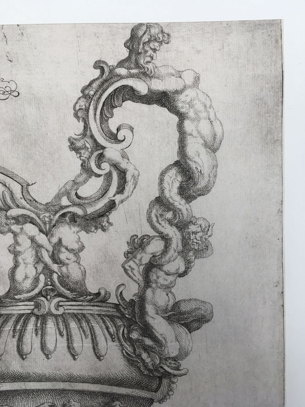 A detail of a fantastical etching of a ewer focuses on a putto sitting on the vessel. He brings a conch to his mouth. Also visible is a nude female harpy embedded in the ewer's neck.