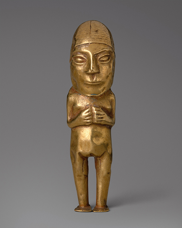 An oversized head with large almond eyes and pursed lips tops a gold figurine of woman. She pulls her hands and arms close to her slightly protruding chest.