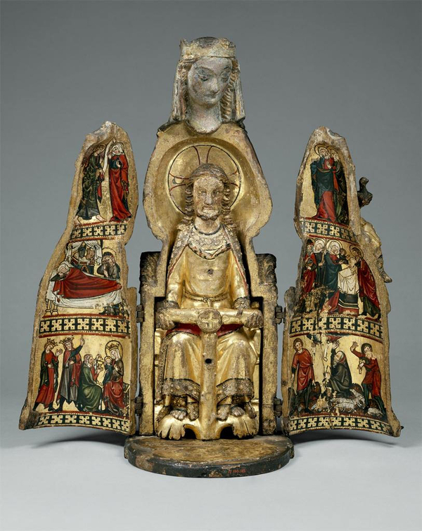 The body of a crowned, light-skinned female statuette swings open to reveal a smaller statue inside of a enthroned, light-skinned figure wearing gold. The open doors are painted gold inside and include vignettes of robed figures.