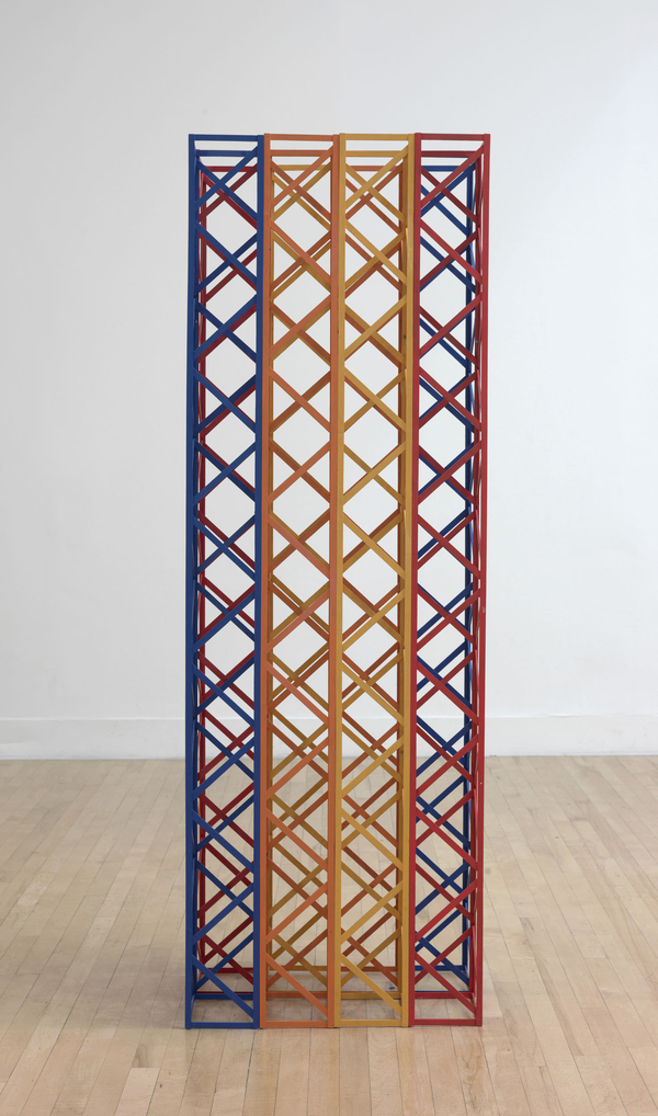 A wooden sculpture consists of eight six-foot-tall lattice structures arranged in a two-by-four array. They are painted bright blue, orange, yellow, and red.