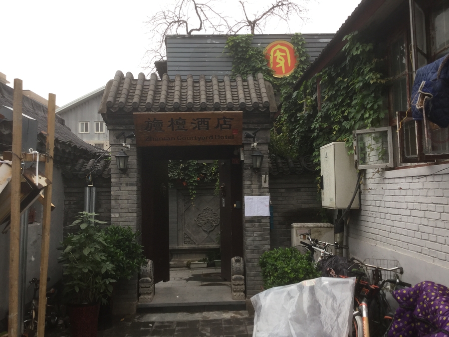 Image of a hotel entrance with tiled roof and elaborate frieze