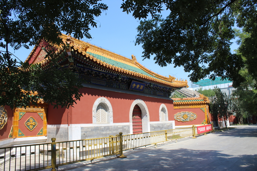 Red building with elaborate arched entry and tiled, curved green roof