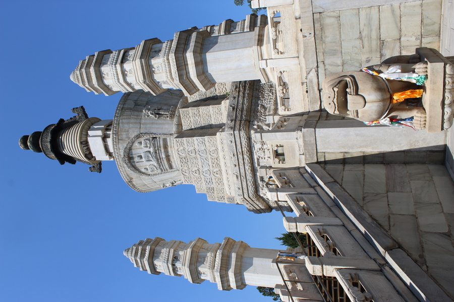 A large memorial stupa stands between and behind two towers that flank a staircase