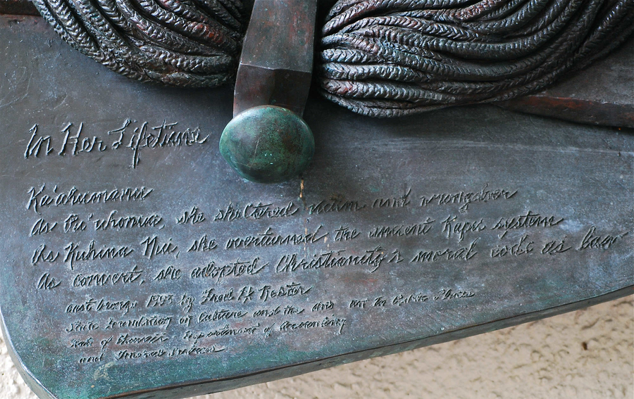 There is engraved script on a corner of a bronze plaque. It reads, "In Her Lifetime. As Kuhina Nui, she overturned the ancient Kapu system. As convert, she adopted Christianity's moral code as law."