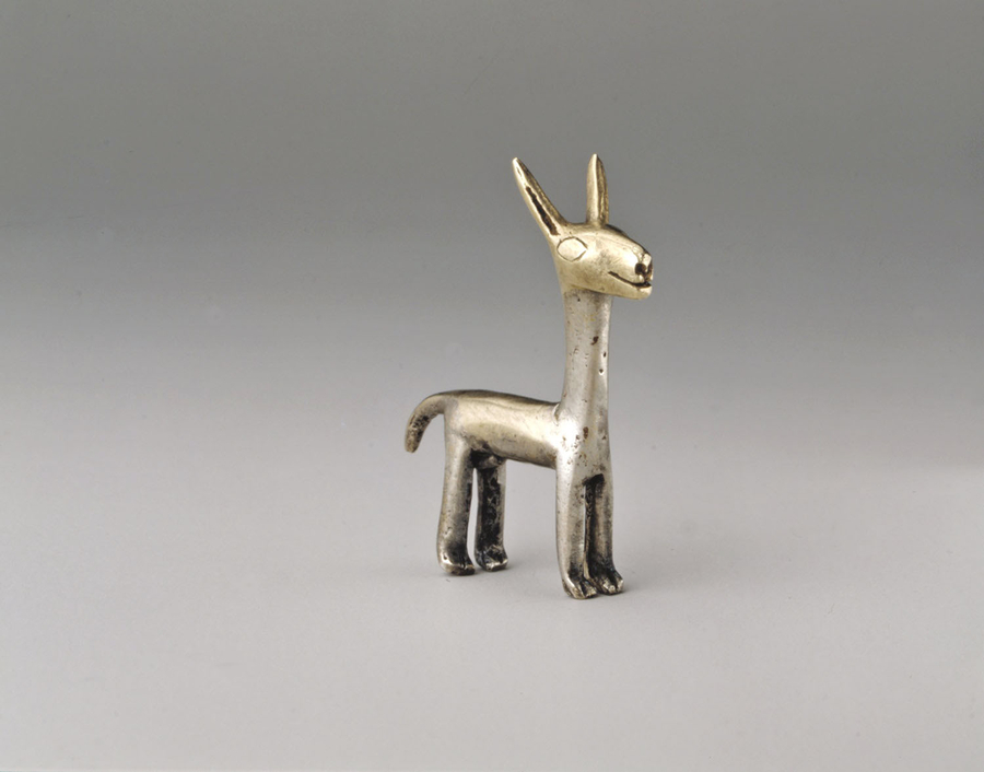 A small, silver llama figurine with a long neck and short tail includes tall, pointed ears, incised eyes, and flared nostils on a solid head.
