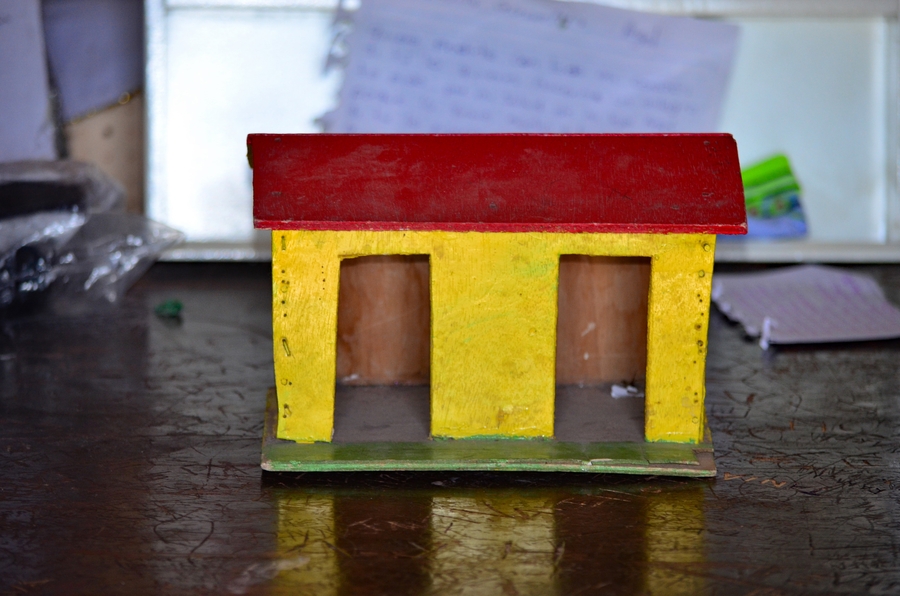 Shrine that resembles a small house painted red and yellow
