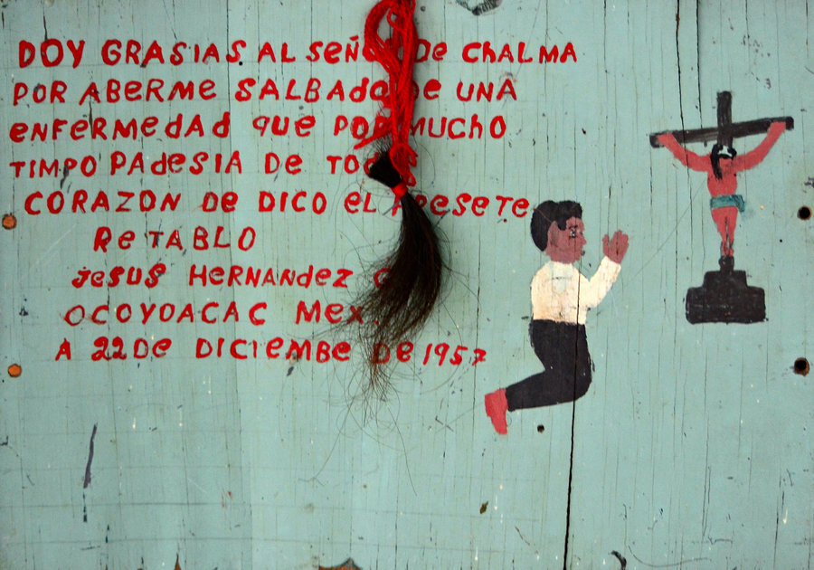 Handpainted devotional image on wood featuring red text, a man on his knees in prayer, and a crucifixion 
