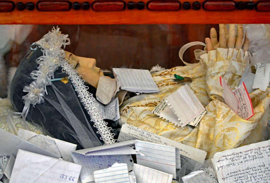 Model of a female saint surrounded by handwritten notes