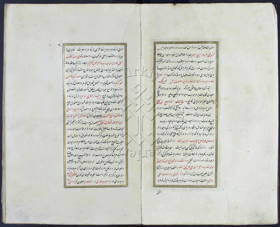 A manuscript lies open to a spread of black and red Arabic calligraphy framed by a gold border. 