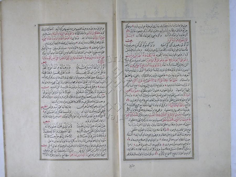 An Islamic manuscript is open to a spread of red and black Arabic calligraphy.