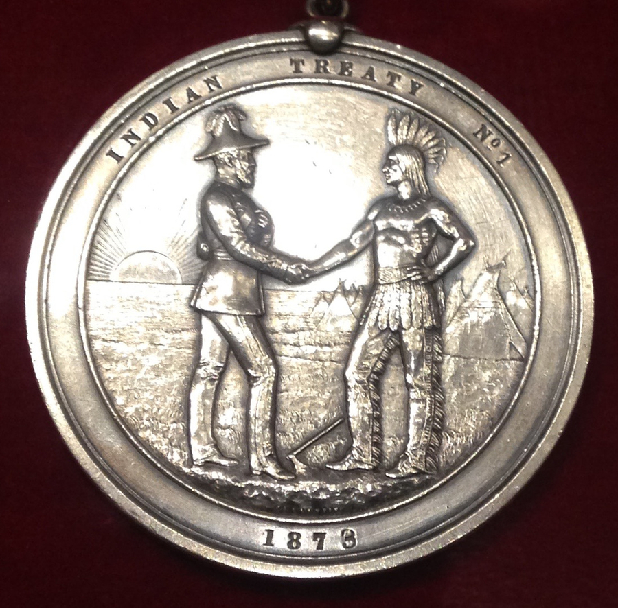 Silver medal with a European soldier and an Indigenous man of Turtle Island shaking hands