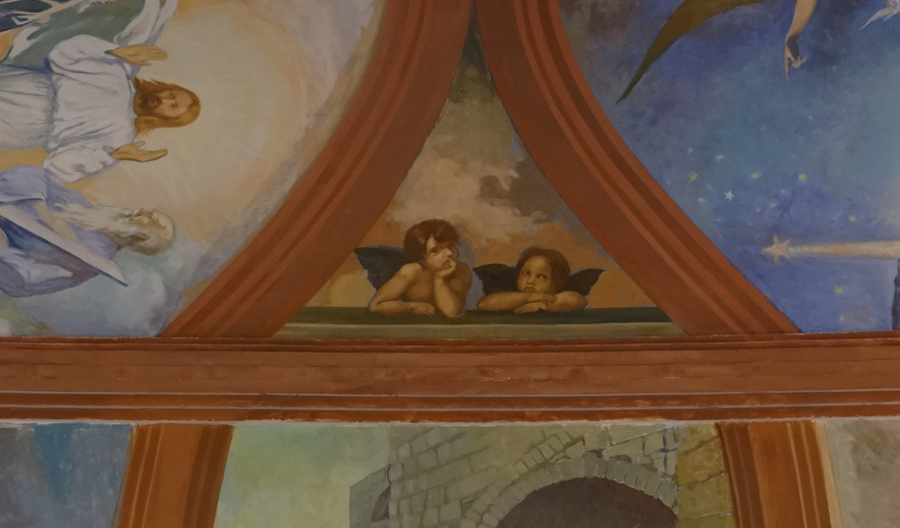 A small scene within a church mural program depicts two winged putti resting on their elbows.